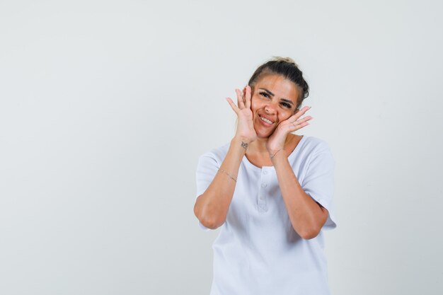 Young lady posing while standing in t-shirt and looking delicate  