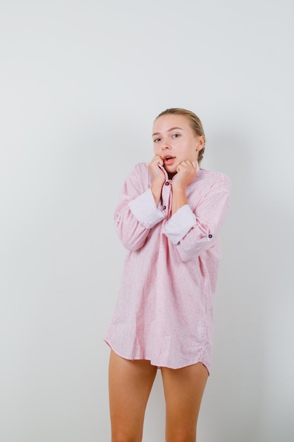 Free Photo young lady pulling collar in pink shirt and looking cute