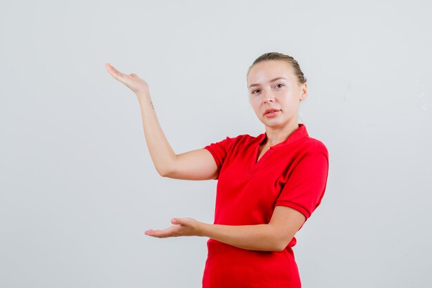 Young lady in red t-shirt welcoming or showing something