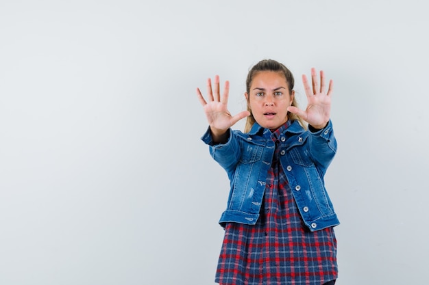 Free photo young lady in shirt, jacket showing stop gesture and looking confident , front view.