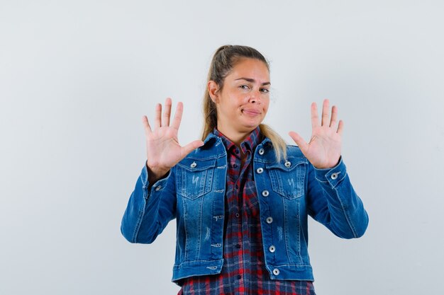 Young lady showing refusal gesture in shirt, jacket and looking confident , front view.