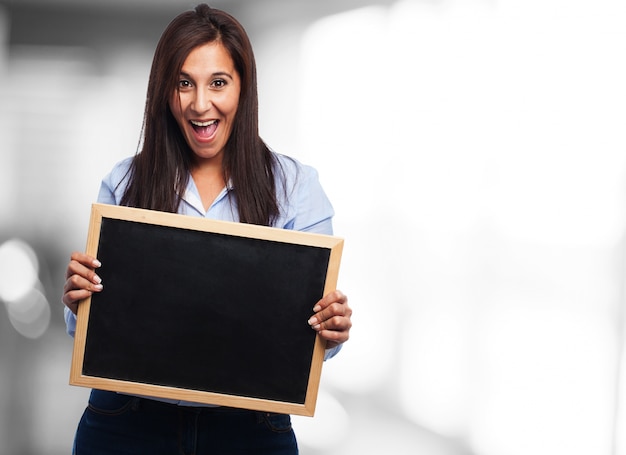 Young lady smiling while holding a slate board