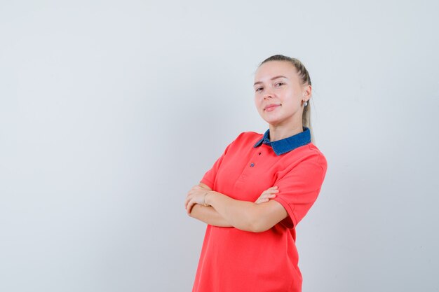 Young lady standing with crossed arms in t-shirt and looking confident