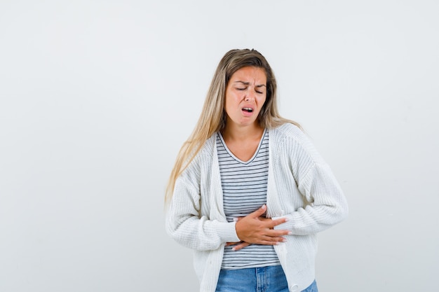 Free photo young lady in t-shirt, jacket suffering from stomach pain and looking unwell , front view.