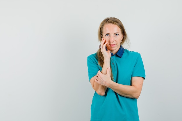 Free Photo young lady touching her skin on cheek in t-shirt and looking delicate 