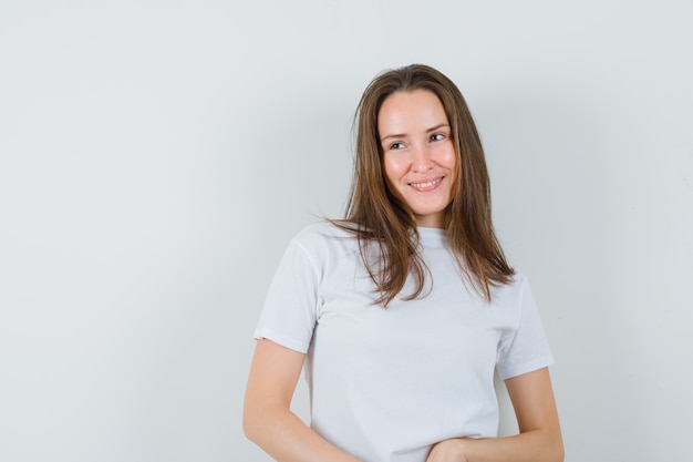 Young lady in white t-shirt looking away and looking charming  