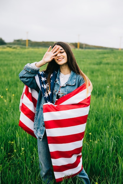 Free Photo young lady with american flag staying in field