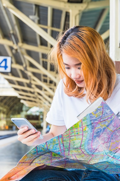 Free photo young lady with smartphone and map