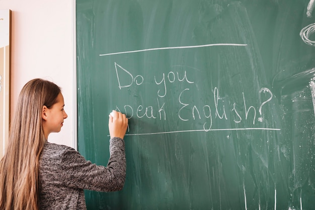 Free photo young lady writing on chalk board