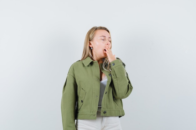 Free Photo young lady yawning in jacket, pants and looking sleepy. front view.