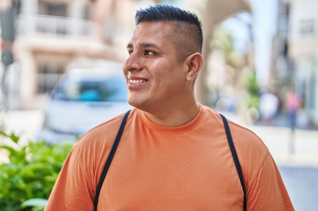 Free photo young latin man smiling confident looking to the side at street