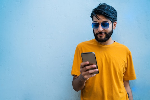 Young latin man using his mobile phone.