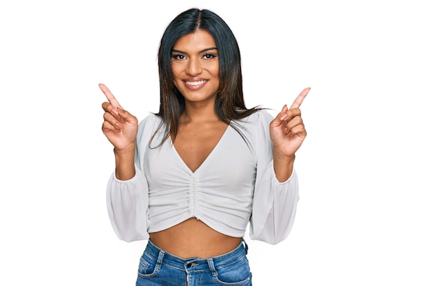 Free photo young latin transsexual transgender woman wearing casual clothes smiling confident pointing with fingers to different directions copy space for advertisement