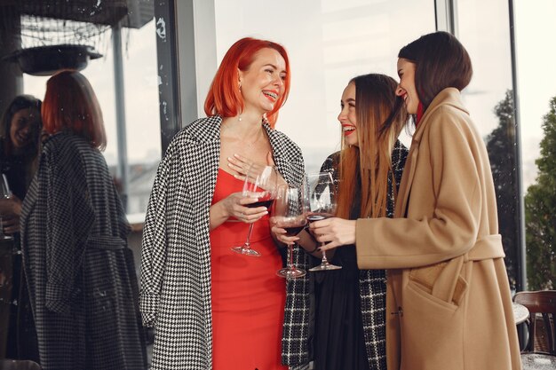 Young laughing friends drinking rose wine from glass outside.