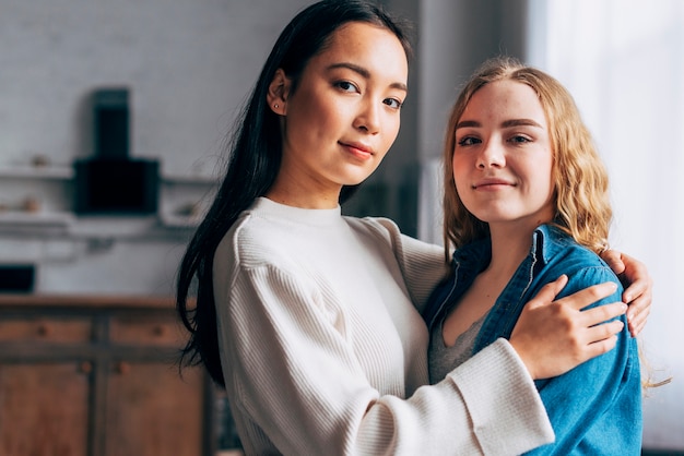 Young lesbian couple embracing at home