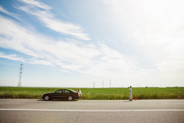 Free photo young lesbian's couple going to vacation trip on the car in sunny day