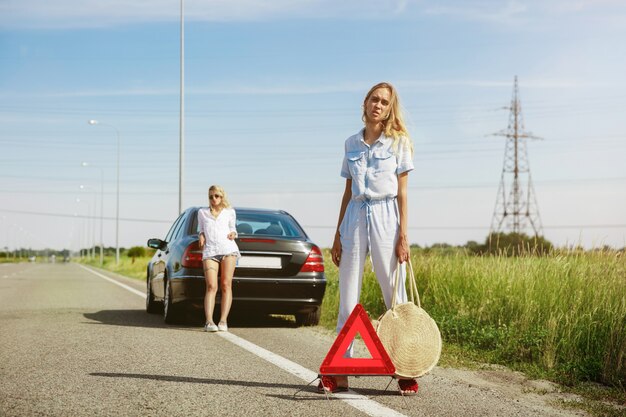 Young lesbian's couple going to vacation trip on the car in sunny day