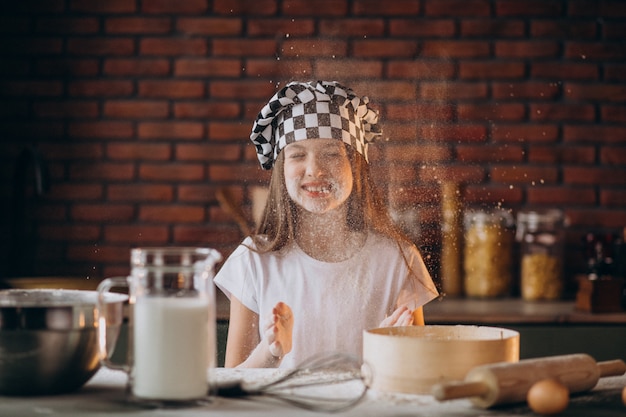 Young little girl baking pastry at the kitchen for breakfast