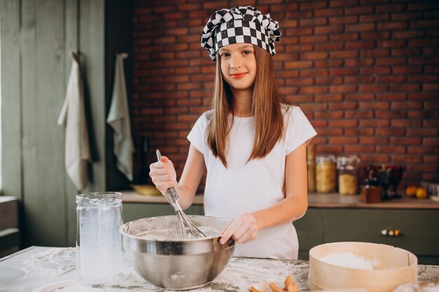 Young little girl baking pastry at the kitchen for breakfast