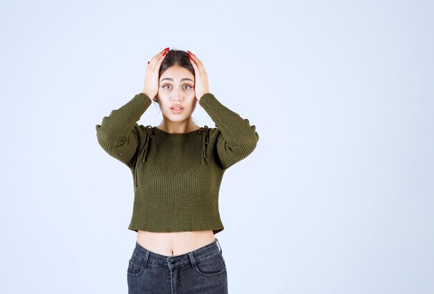 A young lovely woman model covering her head with her hands