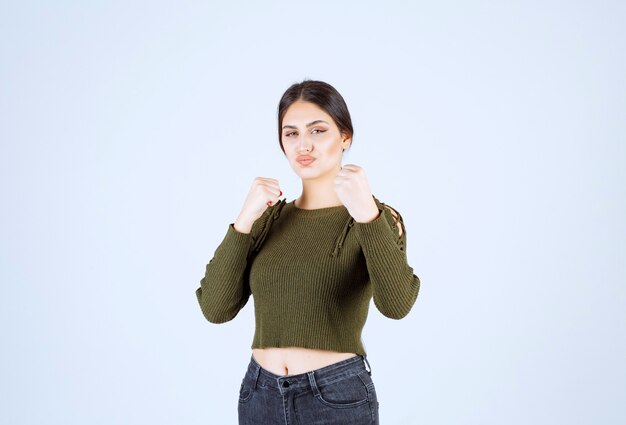 A young lovely woman model in green showing how to punch