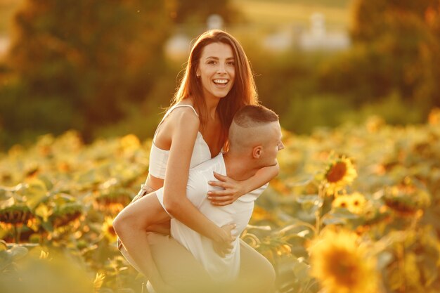 Free Photo young loving couple is kissing in a sunflower field. portrait of couple posing in summer in field.