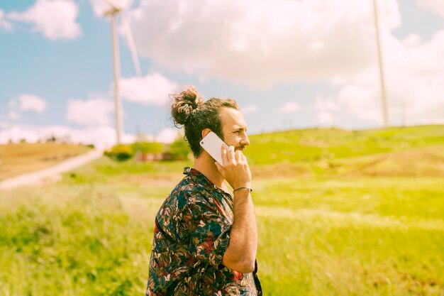 Young male conversing on mobile phone in rural