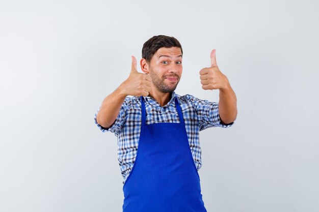 Young male cook in a blue apron and a shirt