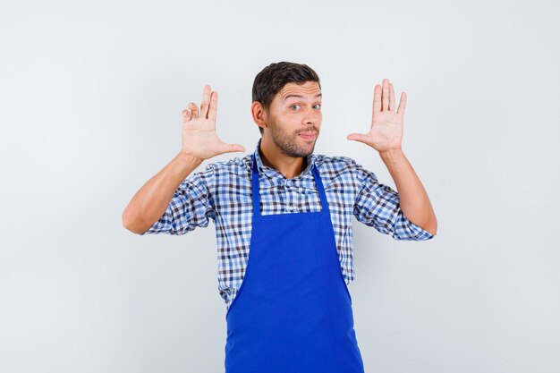 Young male cook in a blue apron and a shirt