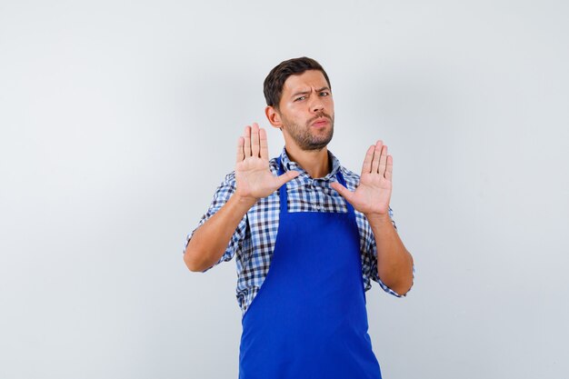 Young male cook in a blue apron and a shirt