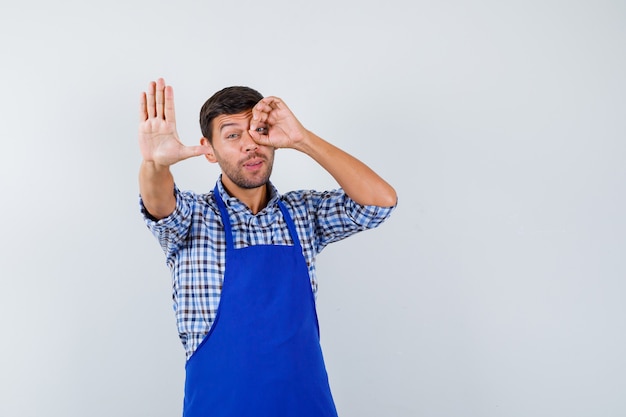 Young male cook in a blue apron and a shirt