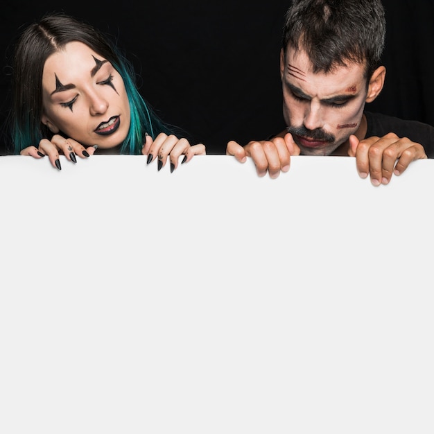 Free Photo young male and female holding wide white sheet