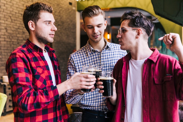 Free photo young male friends enjoying the drink in restaurant