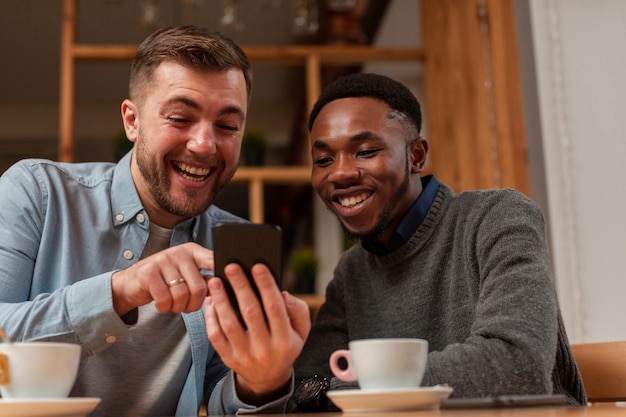 Young male friends looking on mobile