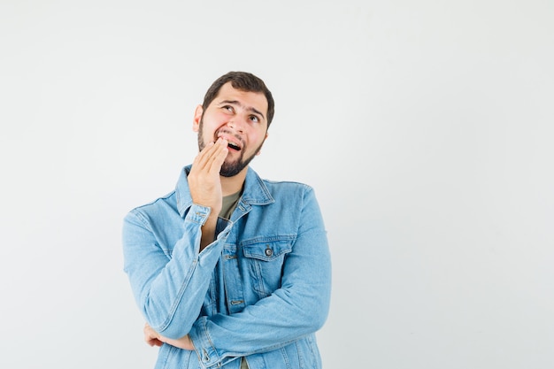 Young male having painful toothache in t-shirt jacket and looking uncomfortable  