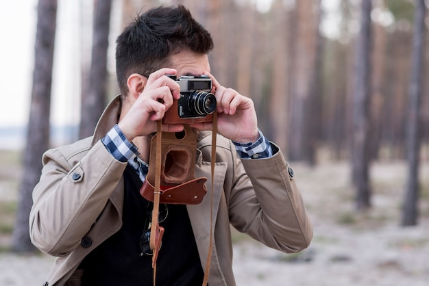 Free Photo young male hiker taking photos with camera