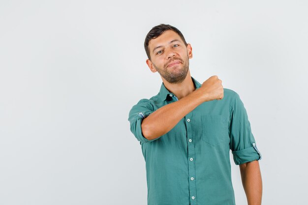 Young male holding clenched fist in shirt and looking confident