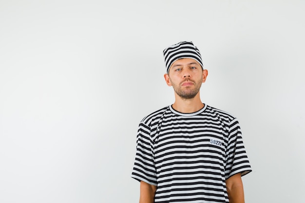 Free photo young male looking at camera in striped t-shirt hat and looking sensible