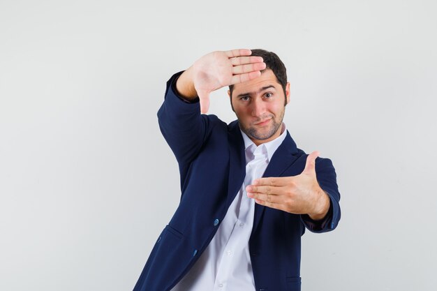 Young male making frame gesture in shirt