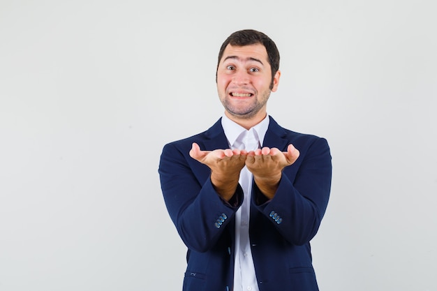 Free photo young male making giving or receiving gesture in shirt, jacket and looking lovely