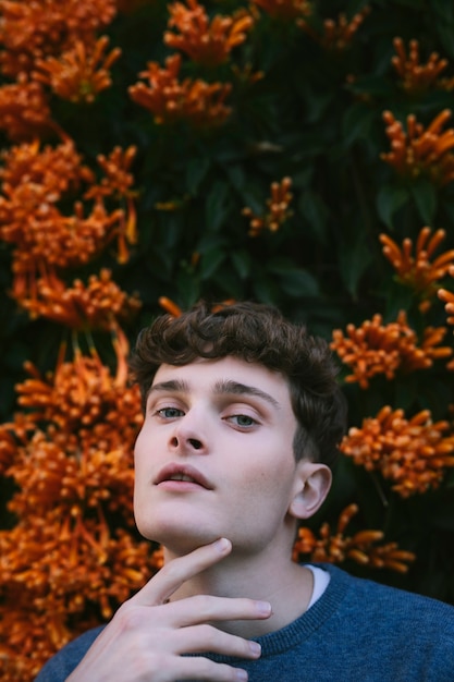 Free photo young male model beside flowers