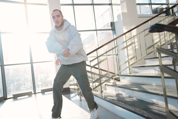 Young male performer dancing in a building next to stairs