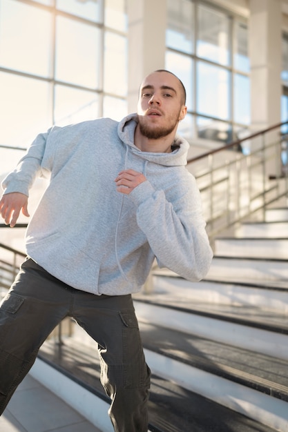 Young male performer dancing in a building next to stairs