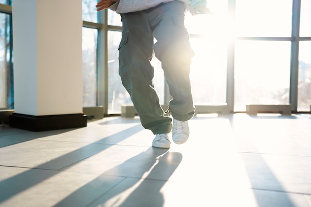 Young male performer dancing in a building with big windows