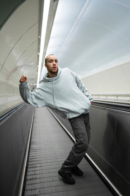 Young male performer dancing on escalators