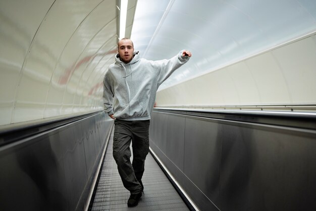 Young male performer dancing on escalators