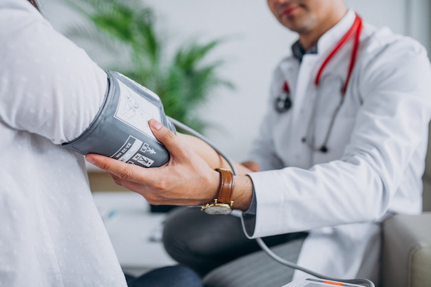 Free photo young male psysician with patient measuring blood pressure