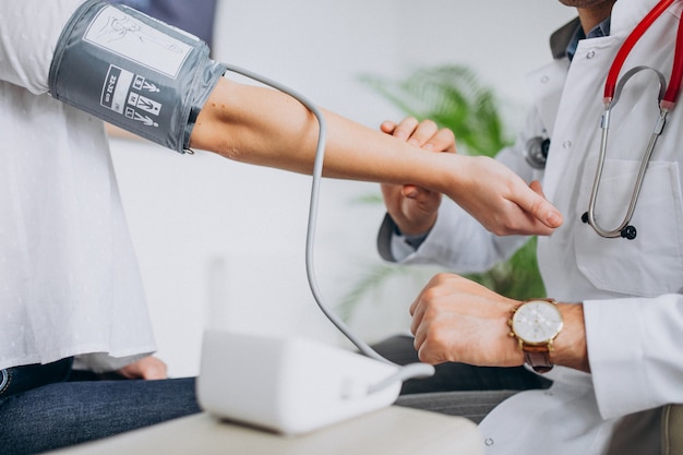 Free photo young male psysician with patient measuring blood pressure