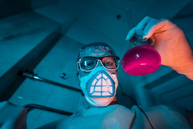 Young male researcher carrying out scientific experiment.