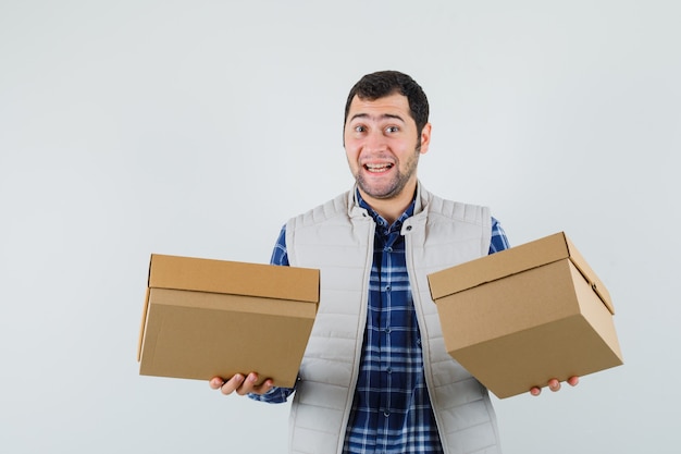 Free Photo young male showing boxes in shirt,jacket and looking joyful. front view.